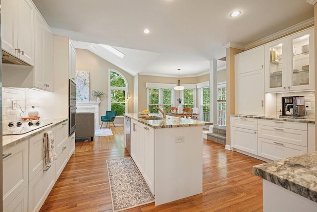 921 Laurel Crest Dr, Woodstock, GA 30189 - kitchen with stainless steel appliances, a sink, a skylight, a kitchen island, and light wood-style floors