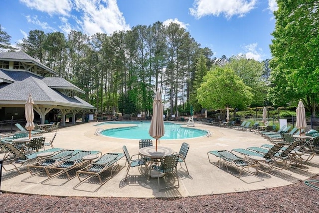 921 Laurel Crest Dr, Woodstock, GA 30189 - community pool featuring a patio and view of wooded area