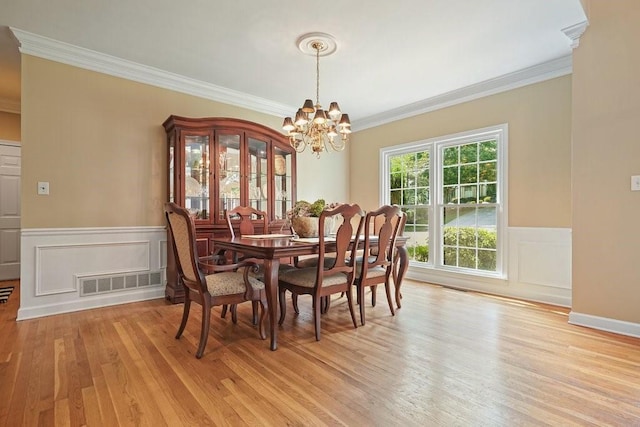 921 Laurel Crest Dr, Woodstock, GA 30189 - dining space with ornamental molding, light wood finished floors, a chandelier, wainscoting, and a decorative wall