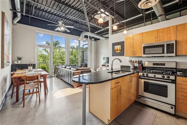 5200 Peachtree Rd Unit 3420, Atlanta, GA 30341 - kitchen featuring stainless steel appliances, a peninsula, open floor plan, finished concrete flooring, and a ceiling fan