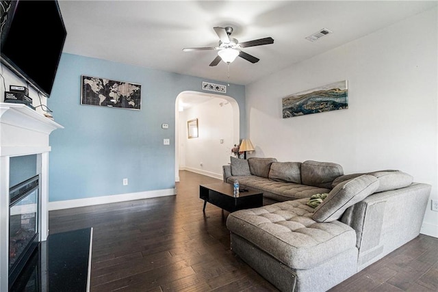 160 Auburn Gate Ln, Auburn, GA 30011 - living room featuring arched walkways, ceiling fan, dark wood-type flooring, and a fireplace with flush hearth