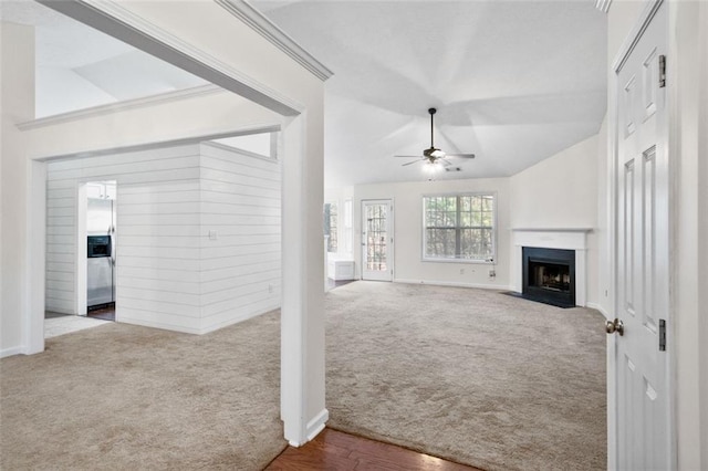 carpeted living room with ceiling fan, lofted ceiling, and ornamental molding