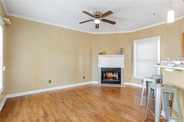 unfurnished living room featuring ceiling fan, crown molding, light hardwood / wood-style floors, and plenty of natural light