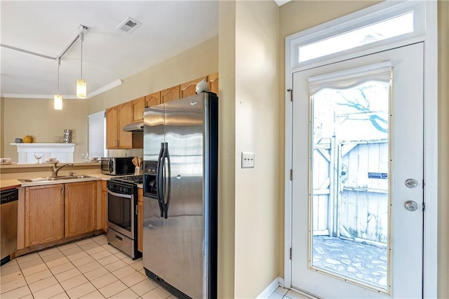 kitchen with appliances with stainless steel finishes, sink, hanging light fixtures, light tile patterned floors, and crown molding