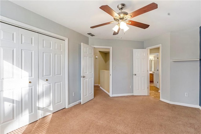 unfurnished bedroom featuring ceiling fan, light carpet, and a closet