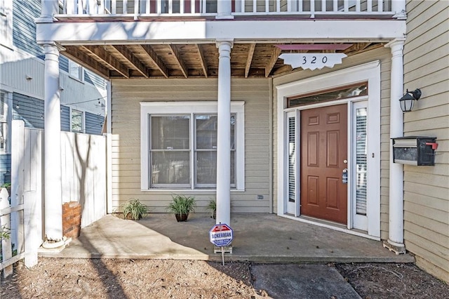 view of exterior entry featuring a balcony