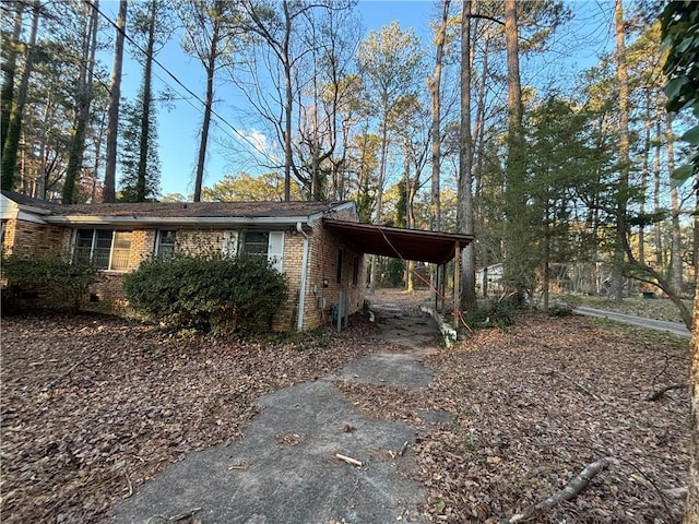 exterior space with crawl space, a carport, and brick siding