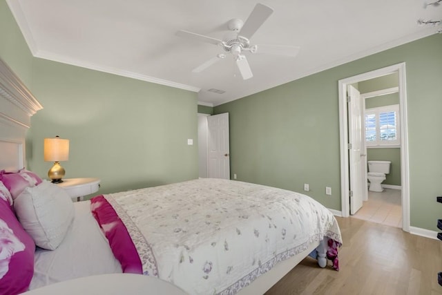 bedroom with visible vents, crown molding, baseboards, and wood finished floors