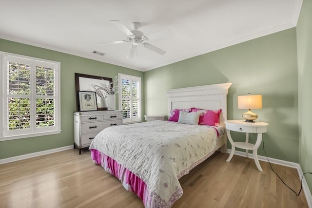 bedroom with ornamental molding, light wood-type flooring, and baseboards