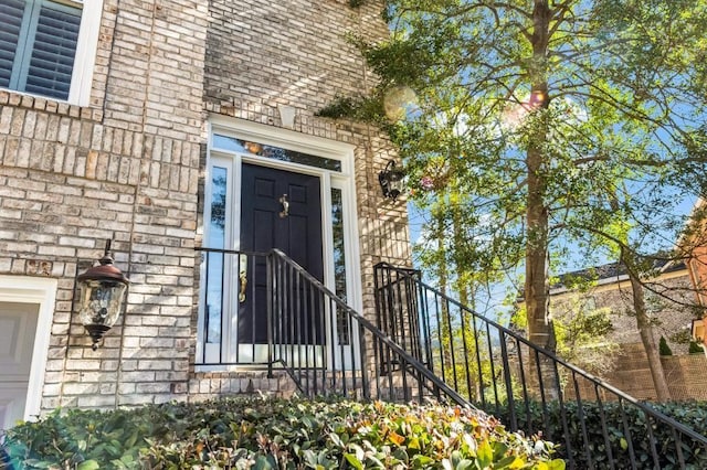 entrance to property featuring brick siding