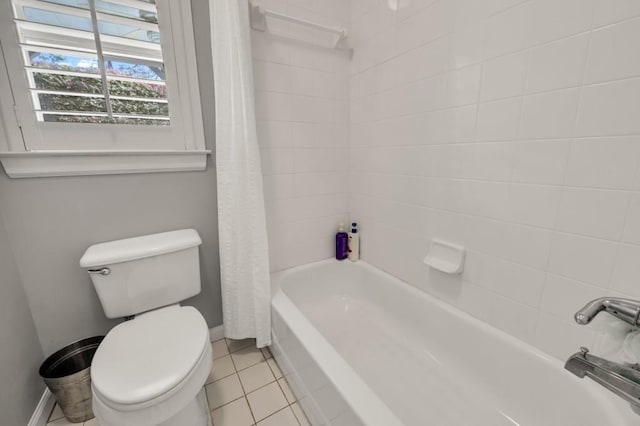 full bathroom featuring tile patterned flooring, baseboards, shower / tub combo with curtain, and toilet