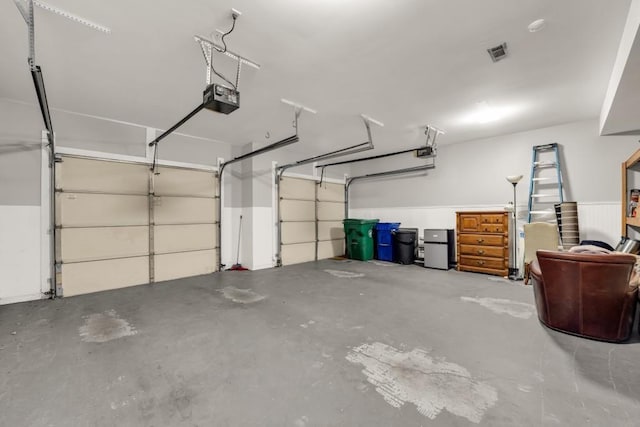 garage with a garage door opener and visible vents