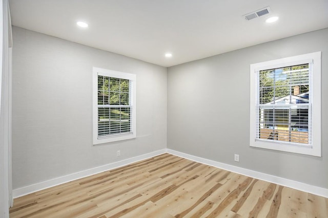 spare room featuring light hardwood / wood-style flooring and a healthy amount of sunlight