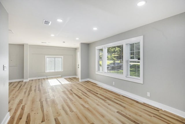 empty room featuring a healthy amount of sunlight and light hardwood / wood-style flooring