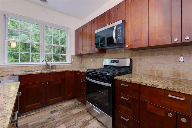 3260 Ridgefair Dr, Cumming, GA 30040 - kitchen featuring stainless steel appliances, a sink, light wood-style floors, tasteful backsplash, and light stone countertops
