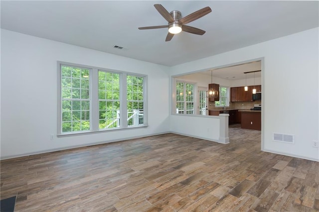 3260 Ridgefair Dr, Cumming, GA 30040 - unfurnished living room featuring wood finished floors, a ceiling fan, and plenty of natural light