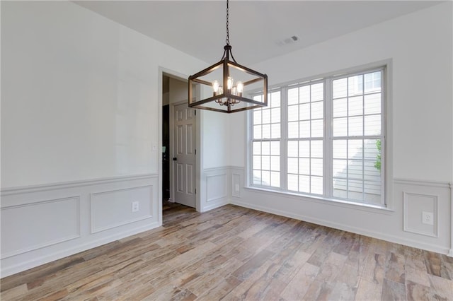 3260 Ridgefair Dr, Cumming, GA 30040 - unfurnished dining area with a chandelier, a decorative wall, a wainscoted wall, and light wood-type flooring