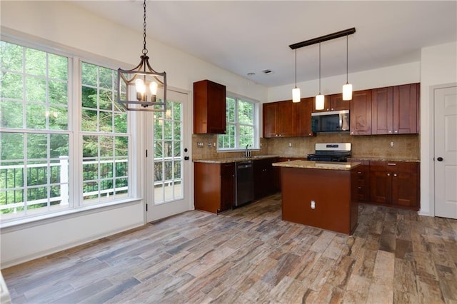 3260 Ridgefair Dr, Cumming, GA 30040 - kitchen with appliances with stainless steel finishes, wood finished floors, decorative backsplash, a center island, and a chandelier