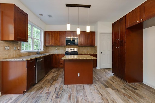 3260 Ridgefair Dr, Cumming, GA 30040 - kitchen with appliances with stainless steel finishes, a center island, light wood-type flooring, and decorative backsplash