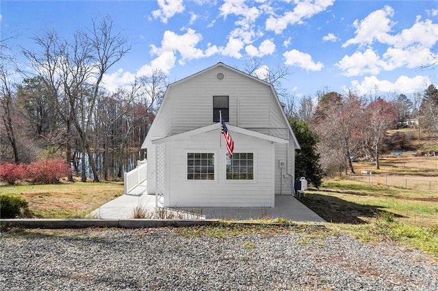 exterior space featuring a gambrel roof, a yard, and fence