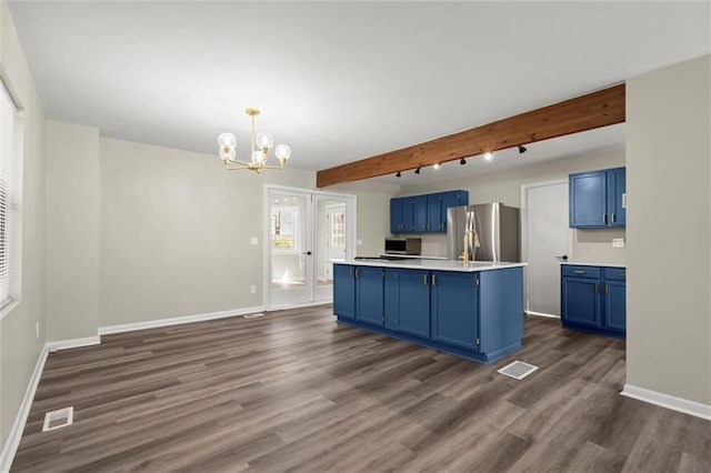 kitchen with visible vents, beamed ceiling, stainless steel appliances, and blue cabinets