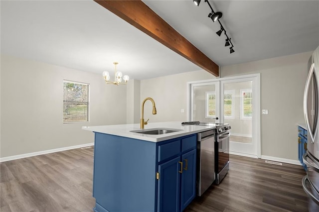 kitchen with blue cabinets, plenty of natural light, range with electric cooktop, and a sink