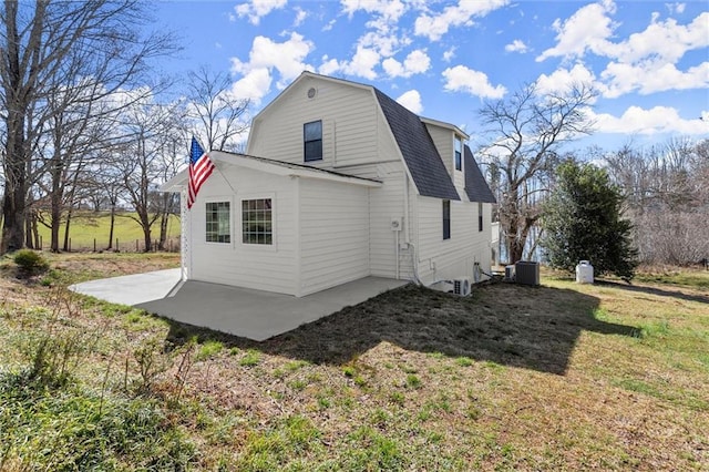 exterior space with a patio, a yard, a gambrel roof, a shingled roof, and central air condition unit