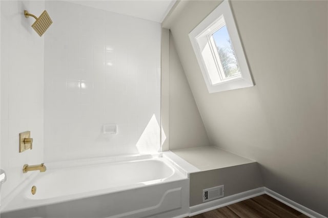 full bathroom with wood finished floors, visible vents, baseboards, a skylight, and toilet