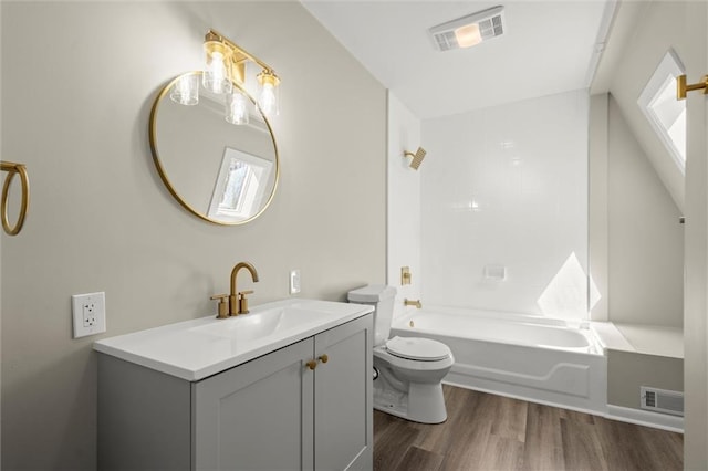 bathroom with vanity, toilet, wood finished floors, and visible vents