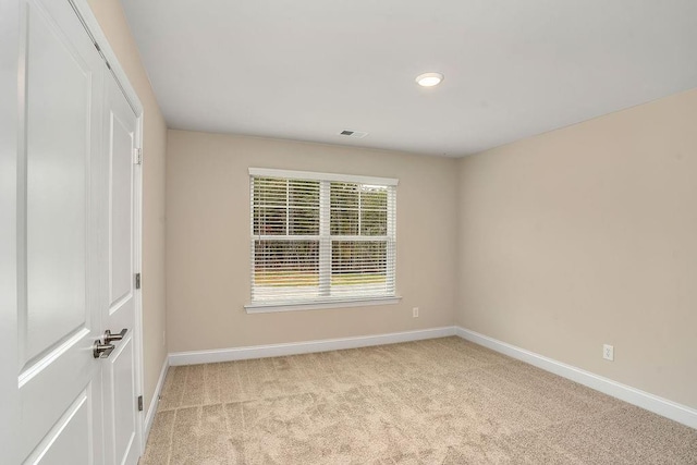 spare room featuring light carpet