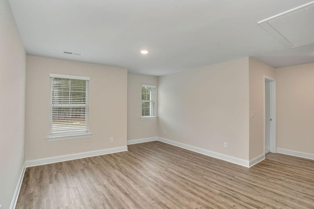 spare room with a wealth of natural light and light hardwood / wood-style flooring