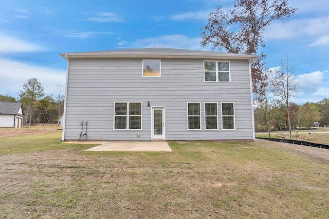 back of property with a yard and a patio