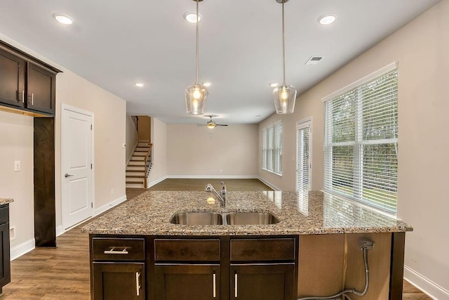 201 Cooper Dr, Mansfield, GA 30055 - kitchen with a sink, dark brown cabinets, light wood-style flooring, a ceiling fan, and decorative light fixtures