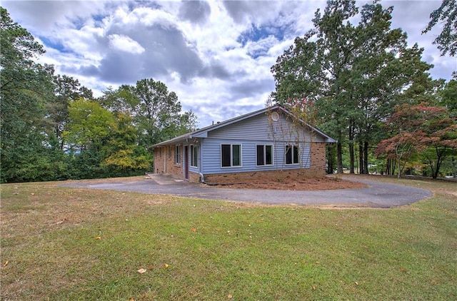 view of front of house with aphalt driveway, a front yard, and brick siding