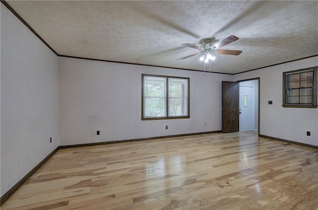 empty room with ceiling fan, a textured ceiling, light hardwood / wood-style flooring, and crown molding