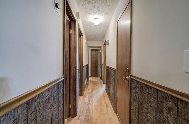 full bathroom featuring a textured ceiling, vanity, shower / bath combination with curtain, tile walls, and toilet