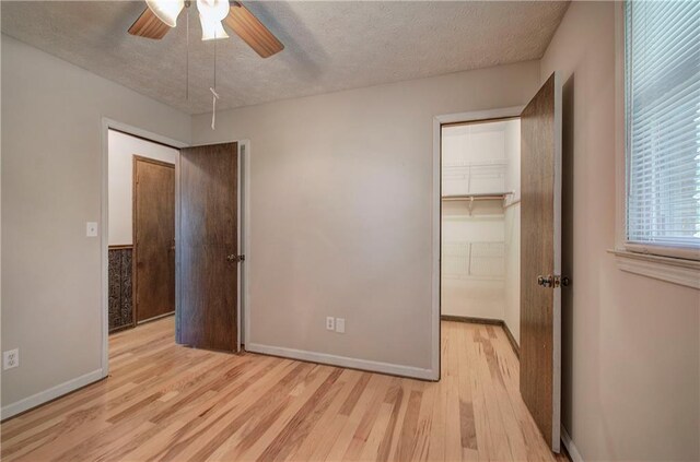 bedroom featuring a textured ceiling, ceiling fan, light hardwood / wood-style floors, and connected bathroom