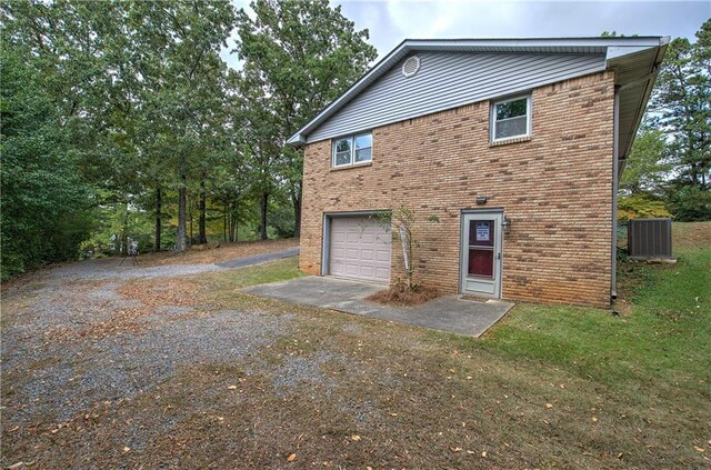 view of property exterior with a garage, a lawn, and central air condition unit