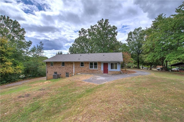 back of house with brick siding, central AC, and a yard