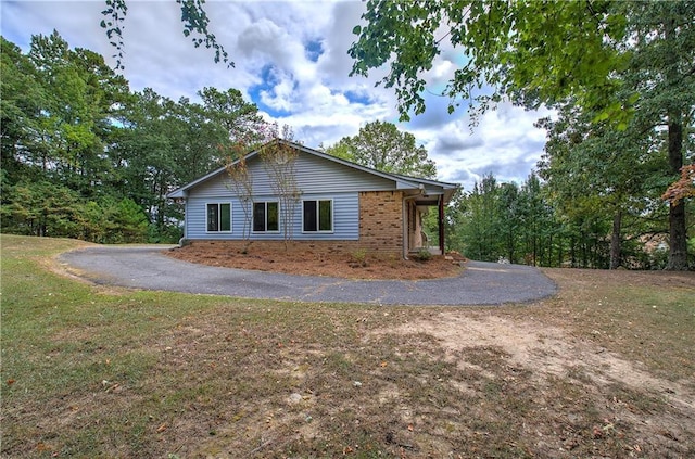 view of side of home featuring a lawn and brick siding