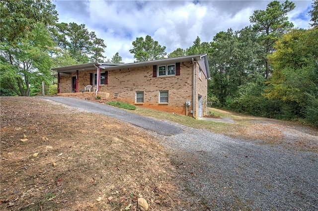 view of front of home featuring driveway, brick siding, and an attached garage