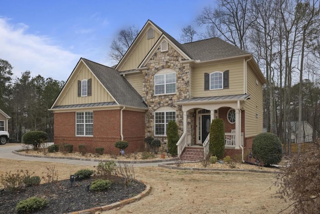 view of front facade featuring board and batten siding, stone siding, brick siding, and a standing seam roof