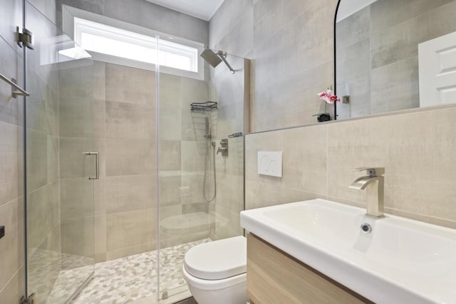 full bathroom featuring tile walls, a shower stall, toilet, and vanity