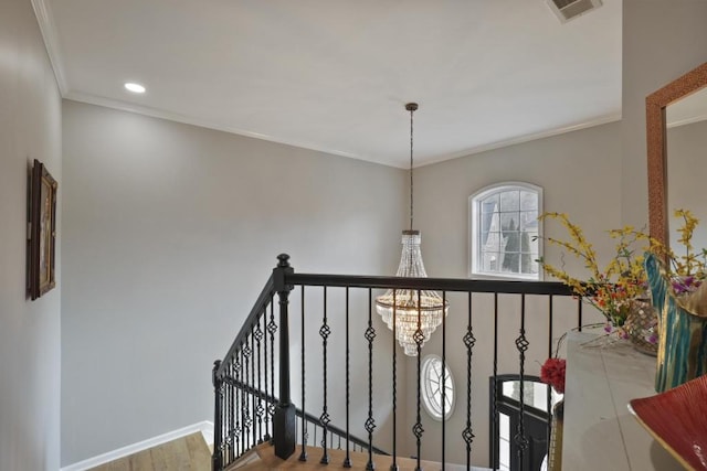 hallway featuring an upstairs landing, baseboards, visible vents, ornamental molding, and an inviting chandelier