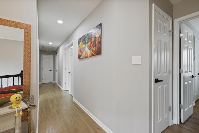 corridor with attic access, recessed lighting, baseboards, and wood finished floors