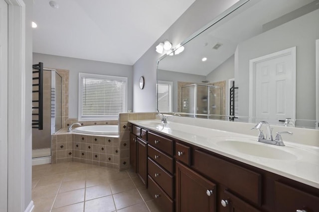 bathroom with lofted ceiling, a garden tub, a sink, and tile patterned floors