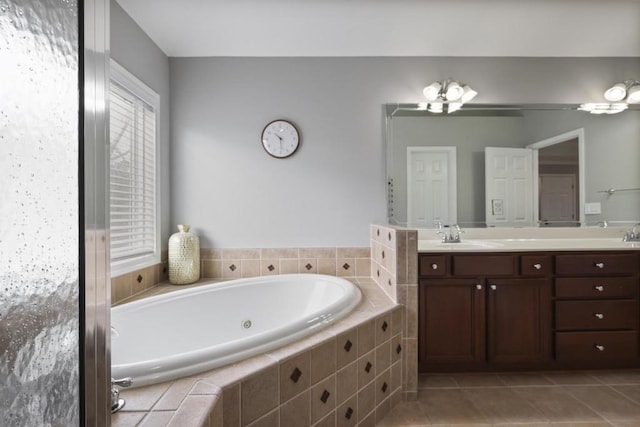 full bath featuring tile patterned flooring, double vanity, a sink, and a bath