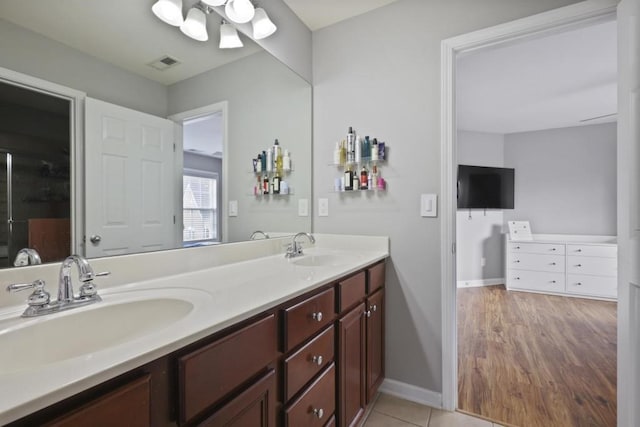 full bathroom with visible vents, a sink, baseboards, and double vanity