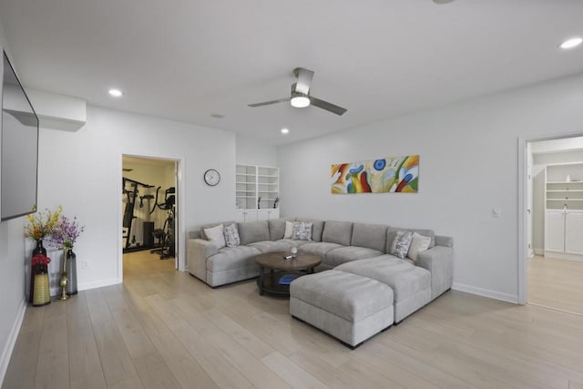 living room featuring light wood finished floors, baseboards, and recessed lighting