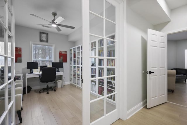 office space with baseboards, a ceiling fan, wood finished floors, and french doors